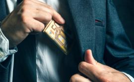 Man in suit pocketing money